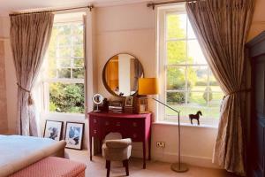 una camera con letto, specchio e tavolo di Somerleyton Meadows - Somerley House plus Hut & Hot Tub a Lowestoft