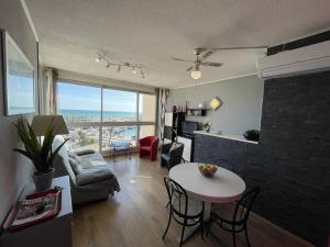 salon z kanapą i stołem z krzesłami w obiekcie Bel appartement T2 cabine avec parking, clim, proche plage et commerces, Saint-Cyprien - FR-1-106-71 w mieście Saint-Cyprien