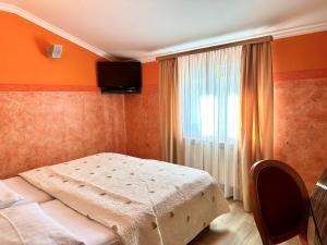 a small bedroom with a bed and a window at Hotel Grahor Depandance in Sežana