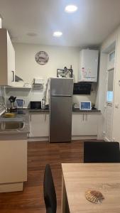 a kitchen with a refrigerator and white cabinets and a table at A de Maria - Tres Marias Apartments in Redondela