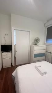 a bedroom with a white bed and a sliding door at A de Maria - Tres Marias Apartments in Redondela