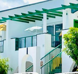 Los PocillosRelaxing upper floor Apartment- exclusive complex.的白色的建筑,边有遮阳篷