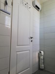a white door in a bathroom with a toilet at Kuća za odmor Kustura in Ilok