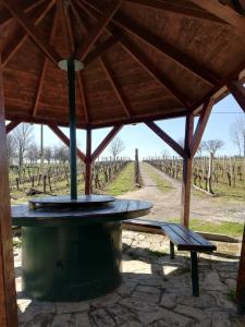 een houten paviljoen met een tafel en een bank in een wijngaard bij Kuća za odmor Kustura in Ilok