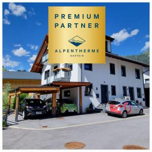 ein gelbes Schild vor einem Gebäude mit geparkten Autos in der Unterkunft The Apartment - Alpentherme inklusive in Bad Hofgastein