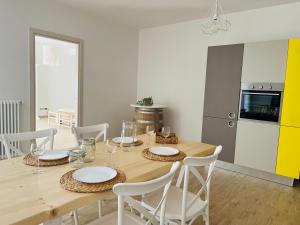 een eetkamer met een houten tafel en witte stoelen bij Villa Maderna in Rutigliano