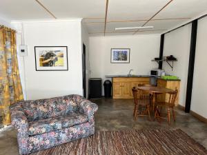 a living room with a couch and a table at Firefly Budget Friendly Guest House in Kempton Park