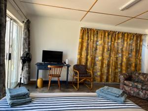 ケンプトンパークにあるFirefly Budget Friendly Guest Houseのベッド、デスク、テレビが備わる客室です。