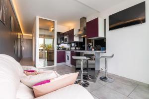 a living room with a white couch and a kitchen at Village Naturiste R4N - Le What Else Port Nature in Cap d'Agde