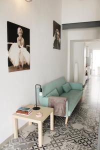 een woonkamer met een groene bank en een tafel bij Casa da Cal Branca in Évora