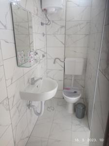 a white bathroom with a sink and a toilet at Studio apartman Sokak in Bihać +23 photos