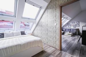 a bedroom with a bed and two windows at Luxury apartment in the city center in Bratislava