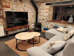 uma sala de estar com um sofá, uma mesa e uma televisão em Casa Bagaro em Serantes
