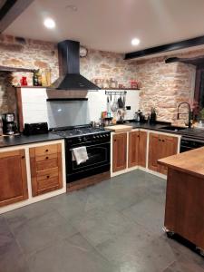 a kitchen with a stove and a stone wall at Casa Bagaro in Serantes