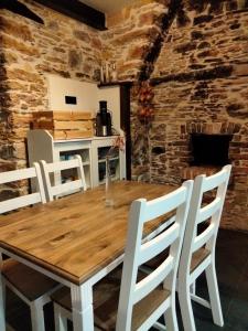 a dining room with a wooden table and white chairs at Casa Bagaro in Serantes