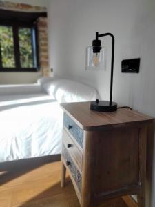 een lamp op een dressoir naast een bed bij Casa Bagaro in Serantes