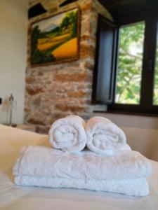duas toalhas sentadas em cima de uma cama em Casa Bagaro em Serantes