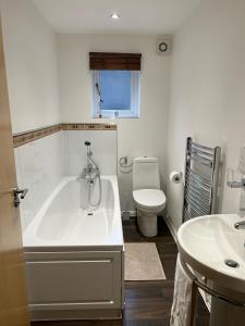 a bathroom with a tub and a toilet and a sink at 116 The Pond House in Holmfirth