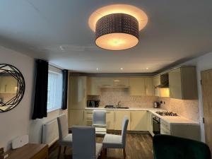 a kitchen with a table and chairs and a light fixture at 116 The Pond House in Holmfirth