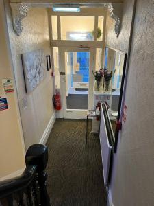 um corredor com uma porta que leva a um quarto com flores em Clifton Private Hotel em Blackpool