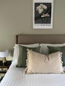 a bed with green pillows and a picture on the wall at Elegant Apartment on Historic Cobbled High St Shrewsbury Town Centre in Shrewsbury