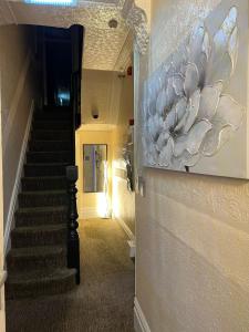 a hallway with stairs and a painting on the wall at Clifton Private Hotel in Blackpool