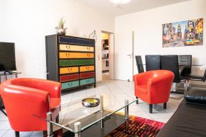 a living room with red chairs and a piano at Art City Studio Kassel 6/9 in Kassel