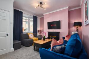 a living room with a blue couch and a fireplace at Stunning House wParking Sleeps7 in Darlington