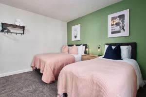 two beds in a room with green walls at Stunning House wParking Sleeps7 in Darlington