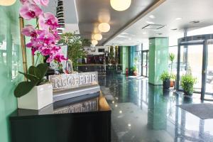 a lobby with plants and flowers on a table at Hotel EMD in Bacău