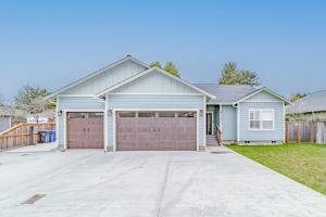 a house with a garage and a fence at Mojo's Dojo in McKinleyville