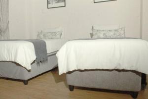 Duas camas sentadas uma ao lado da outra num quarto em Ribbon 210's Two bedroom apartment em Gaborone