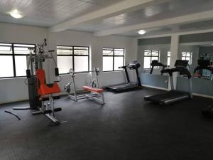 a gym with several exercise equipment in a room at Ribbon 210's Two bedroom apartment in Gaborone