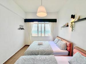 1 dormitorio con 2 camas y ventana en Maison Seaview Suites Port Dickson, en Port Dickson
