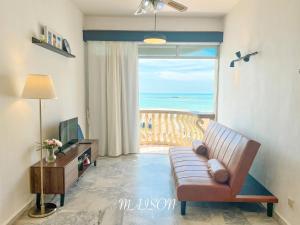 a living room with a couch and a view of the ocean at Maison Seaview Suites Port Dickson in Port Dickson