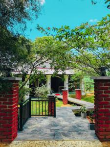 a house with a black gate and a driveway at NATURALIZA in Sigiriya