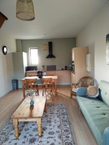 sala de estar con sofá y mesa en Domaine des Cerisiers, en Berville-sur-Mer