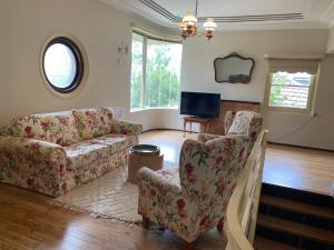 sala de estar con 2 sillas y sofá en Gracious 1930s Art Deco House en Gosford