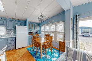 uma cozinha com armários azuis e uma mesa e cadeiras em Assateague Pointe ---12401 Windlass Way em Berlin