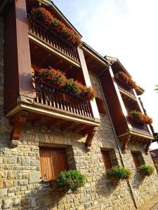 un edificio de piedra con cajas de flores en el balcón en Apartamentos Lausan, en Gavín