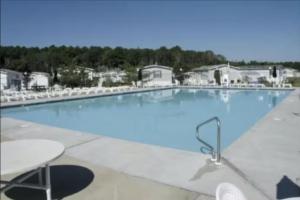 a large blue swimming pool with a table and chairs at Assateague Pointe ---12401 Windlass Way in Berlin