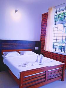 een slaapkamer met een bed met witte lakens en een raam bij SERENITY GREENS in Madikeri