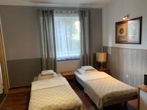 een kamer met 2 bedden en een raam bij Noclegi-Apartamenty Kłodzko Verona in Kłodzko