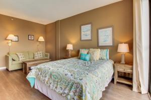 um quarto com uma cama, uma cadeira e candeeiros em Pirates Bay A307 em Fort Walton Beach