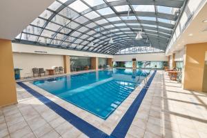 a large swimming pool with a glass ceiling at Hotel EMD in Bacău