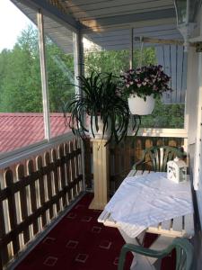 a porch with a table and a potted plant at Tupaniemi, kodikas ja tilava asunto 2-4 vieraalle in Pori