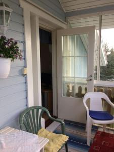 a porch with two chairs and a table and a window at Tupaniemi, kodikas ja tilava asunto 2-4 vieraalle in Pori