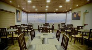 a restaurant with tables and chairs and a large window at Petra Sofsaf Hotel in Wadi Musa