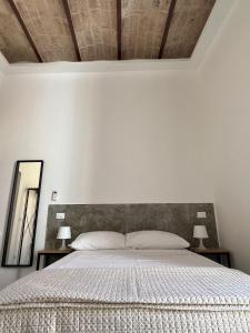 a bedroom with a bed with two lamps and a mirror at Al Vicolo in Terracina