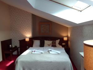 a bedroom with a bed with two towels on it at Hotel Stare Miasto Old Town in Poznań